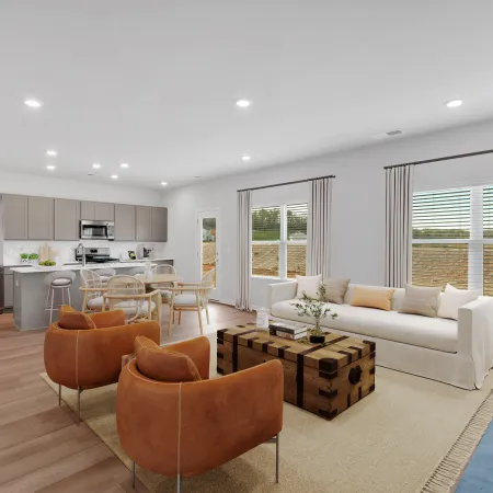 Bright open living room and kitchen with modern furniture, neutral tones, and large windows with curtains.