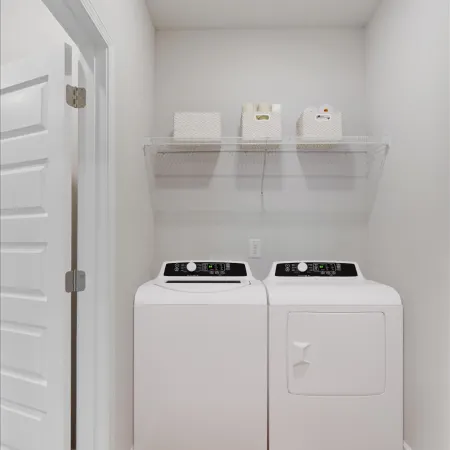 Modern laundry room with white washer and dryer, wall shelf with storage baskets, and wood floor.