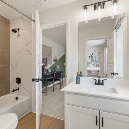 a bathroom with a tub sink and mirror