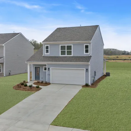 A modern two-story home with a well-maintained lawn and driveway in a suburban neighborhood.