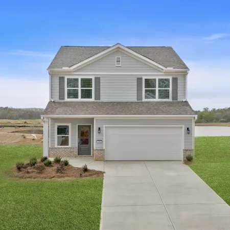 Two-story suburban house with gray siding, double garage, front porch, and green lawn under a blue sky.