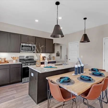 Modern kitchen with stainless steel appliances, granite countertops, and a stylish dining area featuring wood table.