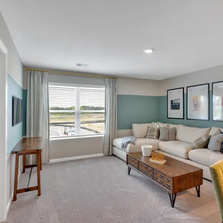 Stylish living room with a cozy sofa, modern decor, and large window letting in natural light.