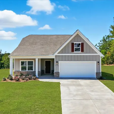 Single-story modern house with gray siding, white trim, brick accents, double garage, and manicured green lawn under blue sky.
