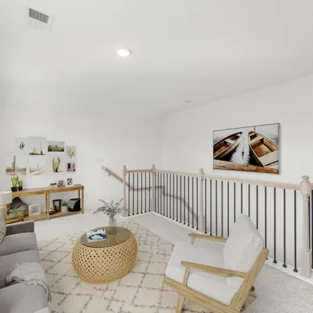 Bright modern living area with gray sofa, armchair, round wicker coffee table, and nature-themed wall art.