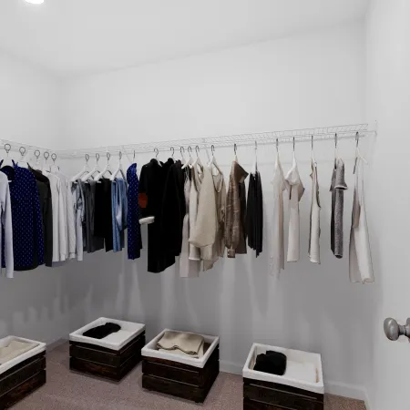 Organized walk-in closet with hanging shirts, sweaters, and storage bins on carpeted floor under bright lighting