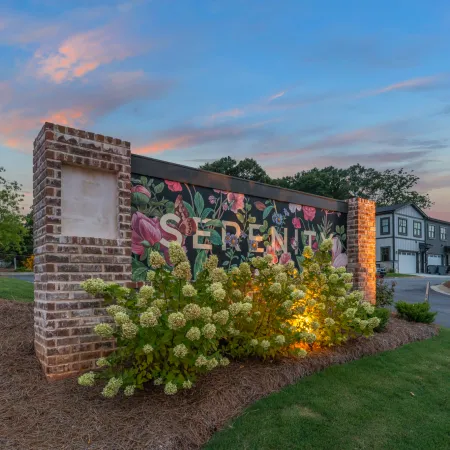 a wall with flowers and a sign