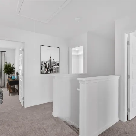 Bright, modern hallway with white walls and soft carpet leading to a cozy living room.
