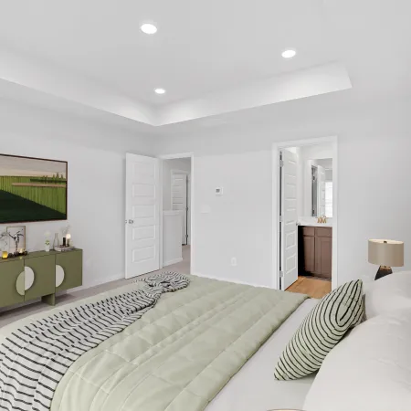 Modern bedroom featuring a green-striped bedspread, sleek decor, and natural light.