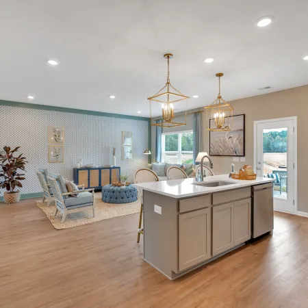 Spacious modern kitchen with wooden floors and stylish island lighting in a bright open layout.