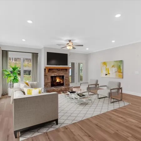 Modern living room with neutral decor, fireplace, and large windows allowing natural light.