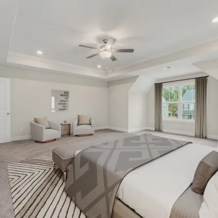 a large bedroom with a bed and couches