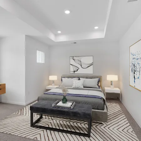 Stylish, modern bedroom with a cozy atmosphere, featuring a desk, artwork, and soft lighting.