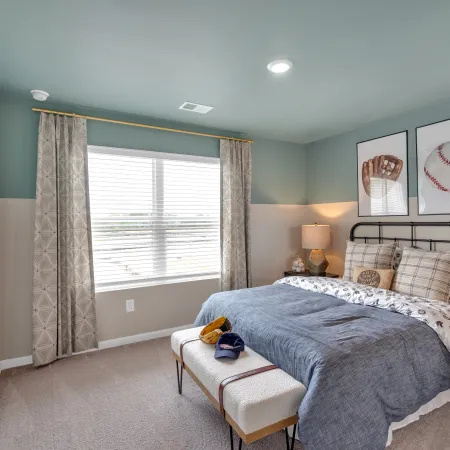 Stylish bedroom featuring blue walls, cozy bedding, and baseball-themed decor.