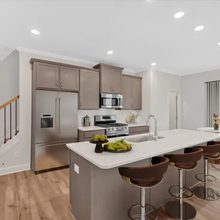 Modern kitchen featuring stylish cabinetry, stainless steel appliances, and a spacious island with bar stools.
