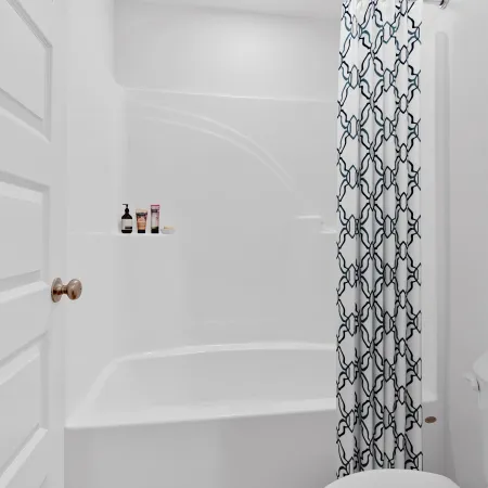 Minimalist white bathroom featuring a bathtub with patterned curtain and wooden floor.