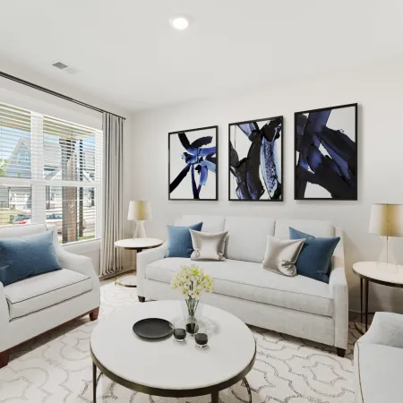 a living room with a white couch and a table with blue pillows