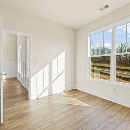 a room with a wood floor and a large window
