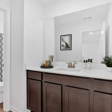 Modern bathroom with a stylish vanity, large mirror, and minimalist decor in neutral tones.