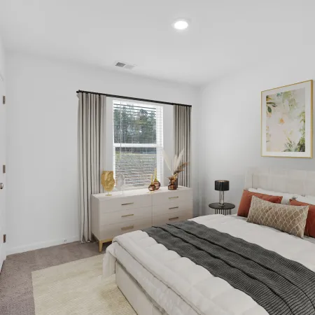 Cozy bedroom featuring a bed, decorative pillows, and natural light from a window with green curtains.