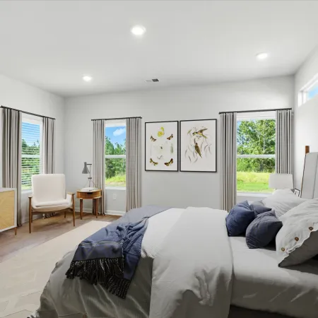 Bright modern bedroom with gray bed, blue and white bedding, wooden furniture, and nature-themed wall art.
