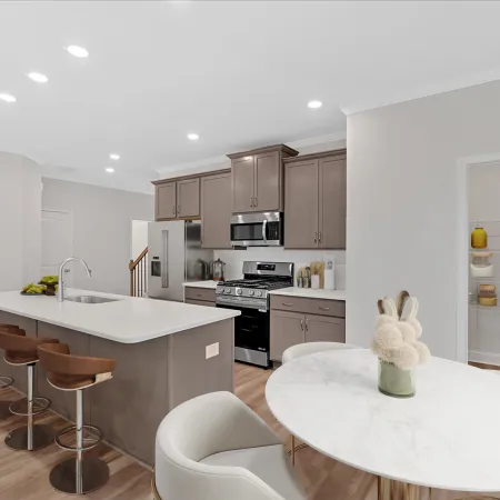 Modern kitchen with gray cabinets, marble table, and stylish bar stools in a bright open space.