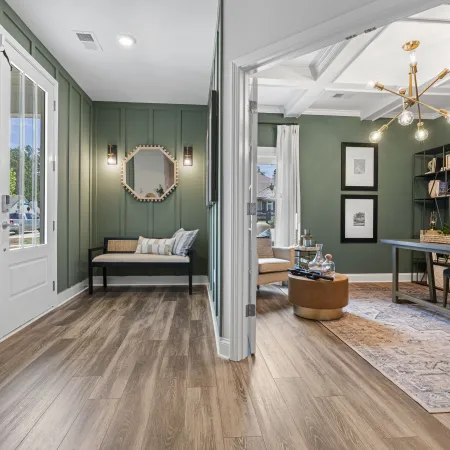 a room with a wood floor and a wood floor with a mirror and a table with a rug