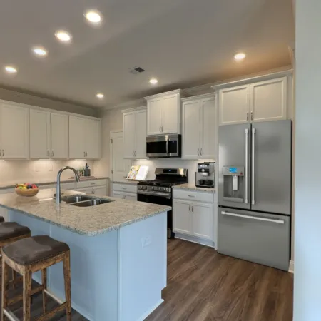 a kitchen with a bar stool and a refrigerator