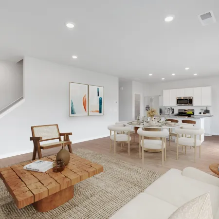 Modern open-plan living and dining area with neutral tones, wooden furniture, and contemporary kitchen in the background