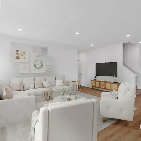 Modern living room with white furniture, wooden floors, wall art, TV console, and bright natural lighting.