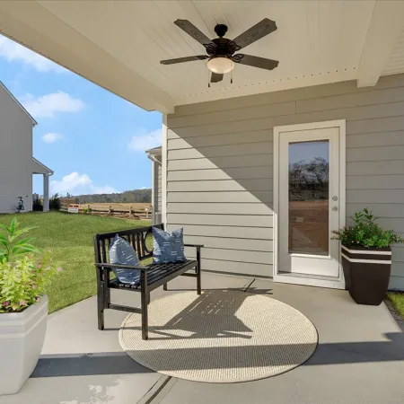 Cozy porch area featuring a bench, plants, and a ceiling fan on a sunny day.