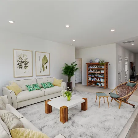 Bright living room with two beige sofas, wooden coffee table, accent chairs, plant, and framed botanical prints.