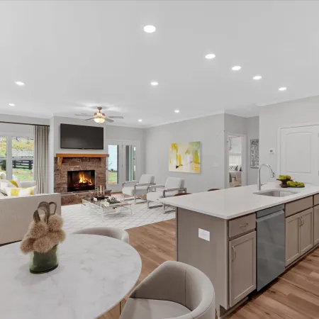 Modern living room with a cozy fireplace, open kitchen, and stylish furnishings in bright decor.