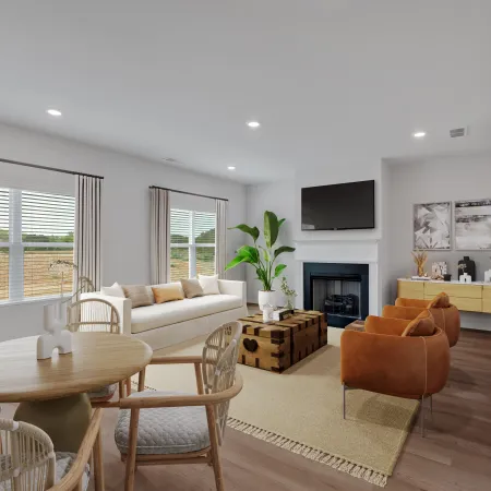Modern living room with beige sofa, brown armchairs, wooden dining table, and TV above fireplace, bright with natural light