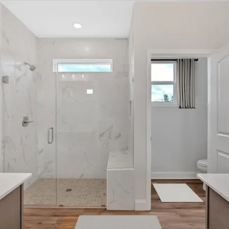 Modern bathroom showcasing a glass shower, sleek vanity, and neutral tones for a spacious feel.