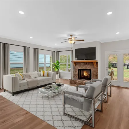 Modern living room with fireplace, large windows, and contemporary furniture, creating a cozy atmosphere.