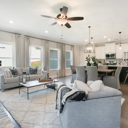 a living room with a large ceiling fan and a large white couch