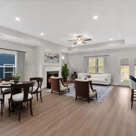 Open concept living and dining area with modern furniture, hardwood floors, ceiling fan, and fireplace in neutral tones.