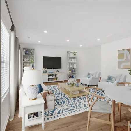 Bright living room with blue patterned rug, white furniture, wooden dining table, and modern TV setup.