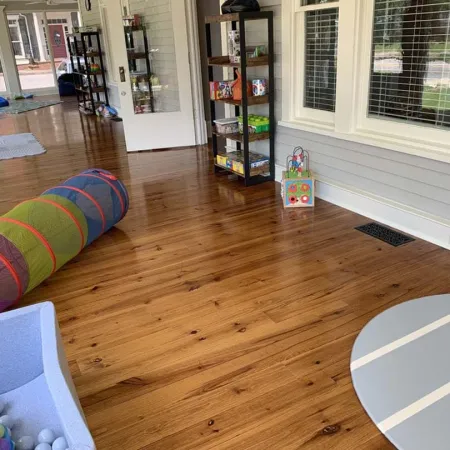 a room with a wood floor and a rug and a window