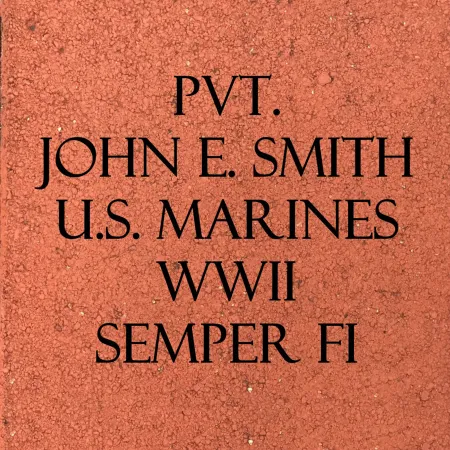Memorial brick with inscription for Pvt. John E. Smith, U.S. Marines, WWII, Semper Fi on a red background.