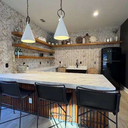 a kitchen with a bar and chairs