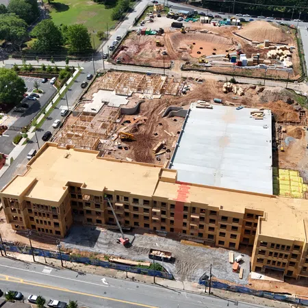 A large multi-story building under construction with ongoing site work and equipment in an urban area.