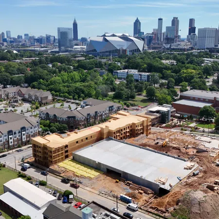 Aerial view of Atlanta city skyline with Midtown construction site and residential buildings in the foreground.