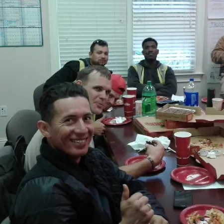 a group of men sitting at a table with food and drinks