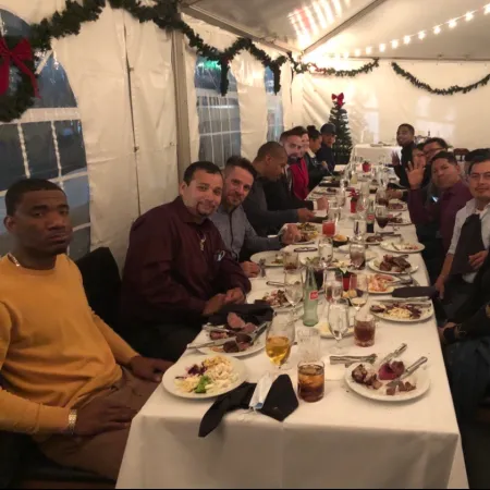 a group of people sitting at a table with food and drinks