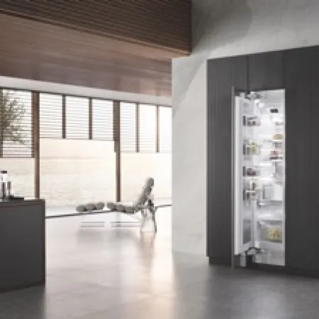 Modern kitchen featuring a sleek, dark refrigerator with clear glass panels and minimalistic decor.