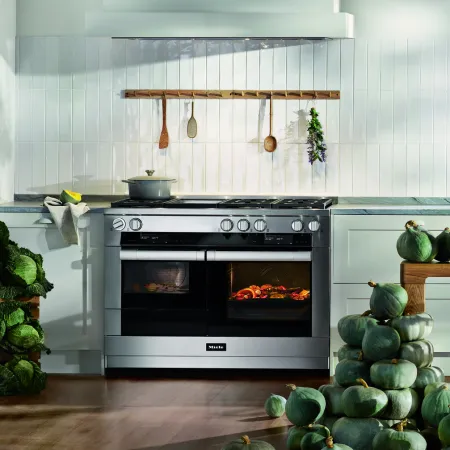 Modern kitchen with a Miele oven and fresh vegetables surrounding it, highlighting culinary elegance.