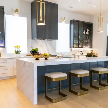 Modern kitchen design featuring marble countertops and sleek cabinetry with gold accents.