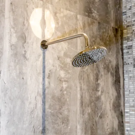 Modern showerhead in a stylish marble tiled bathroom setting, showcasing luxury and elegance.